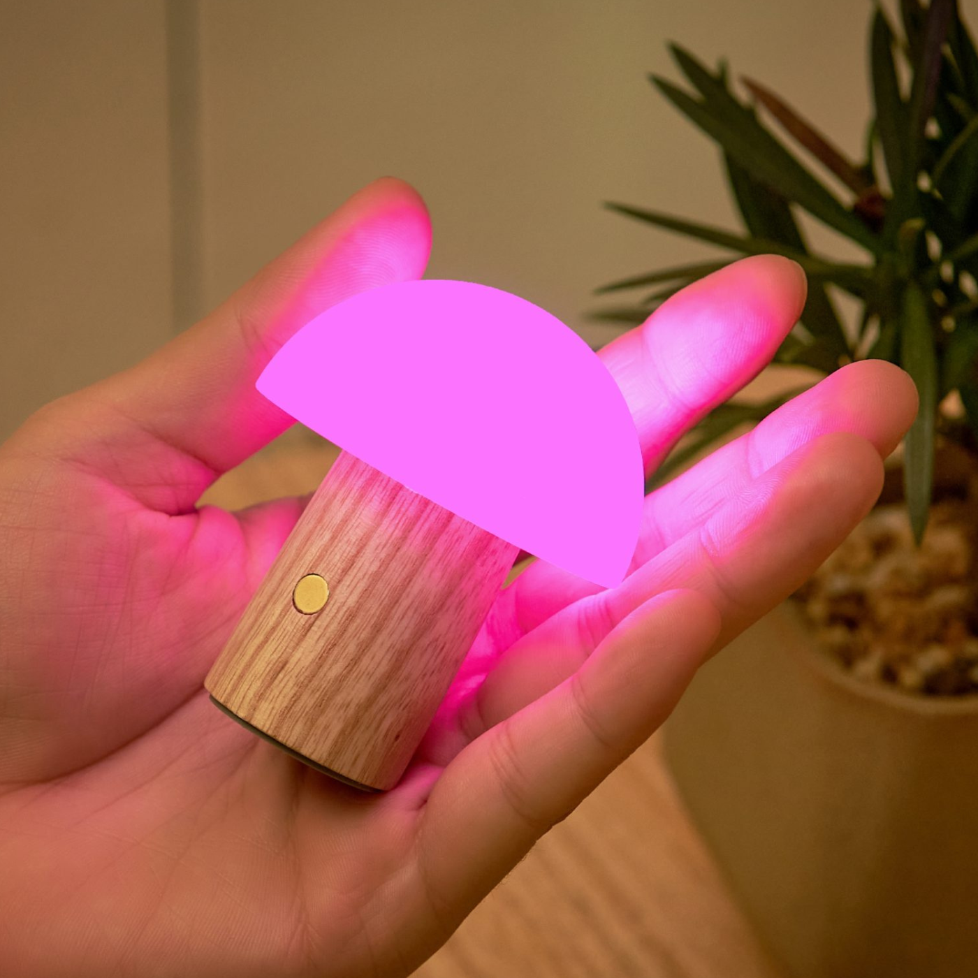 A person holding a small mushroom shaped light in their hand.