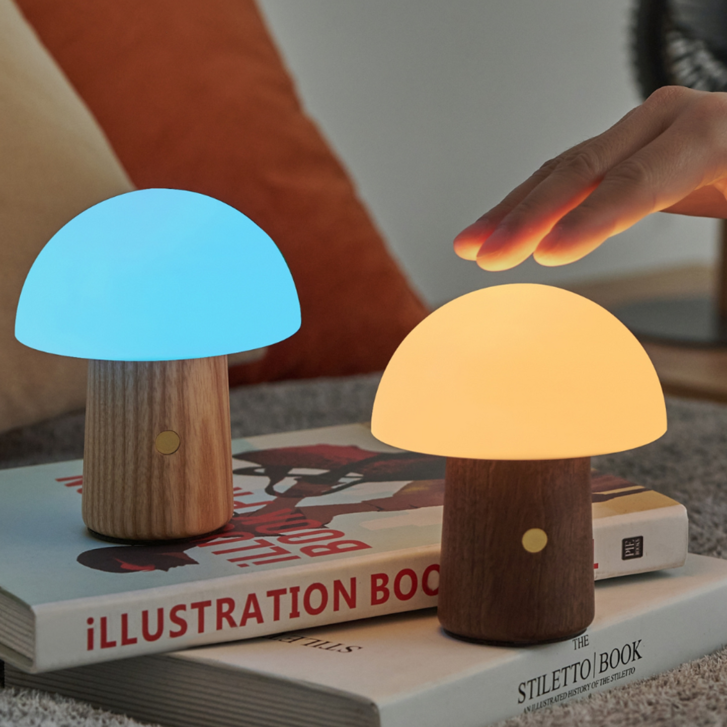 Mushroom shaped small lamps with a wooden base placed on top of a stack of books.