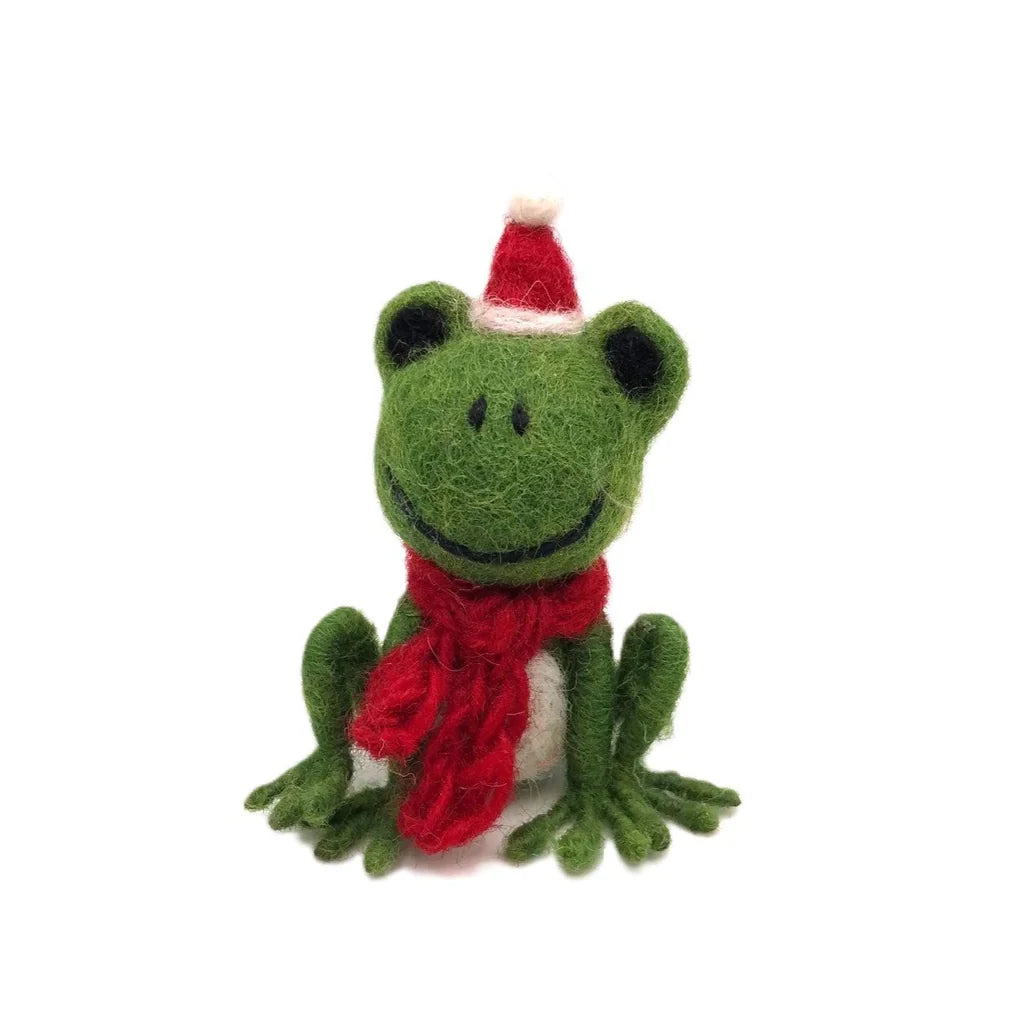 Green felt frog decoration with a red knitted  scarf and Santa hat, sitting against a white background.