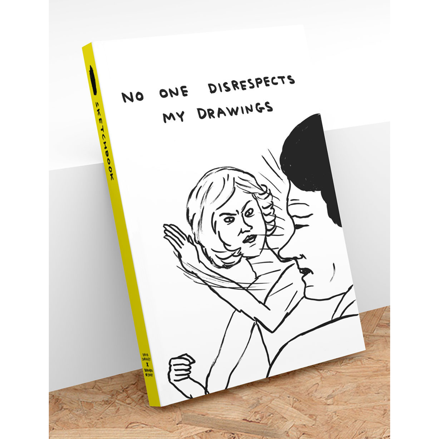 A sketchbook with a black and white illustration of a person embracing a cartoon character. The title 'NO ONE DISRESPECTS MY DRAWINGS' is visible on the cover.