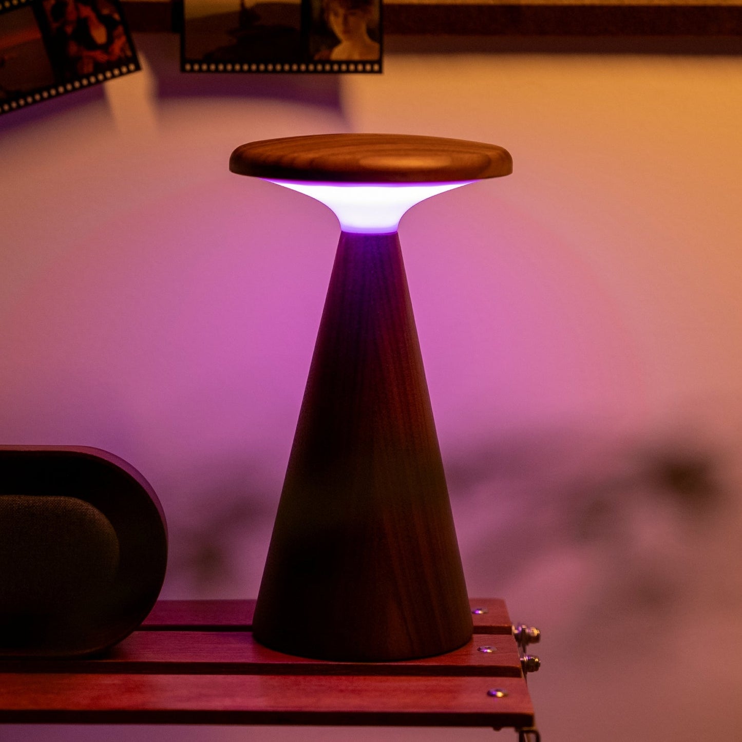 Wooden column shaped lamp with a glowing purple light on a blurred background