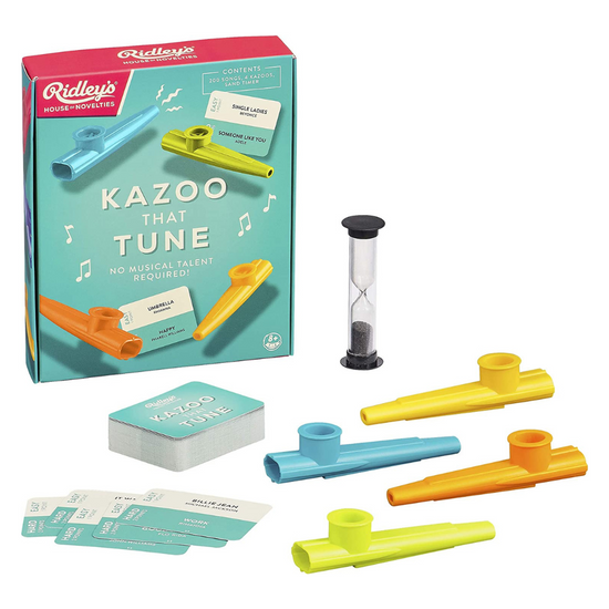Kazoo That Tune music game box packaging with playing cards, whistles and sand timer layed out infront of it.