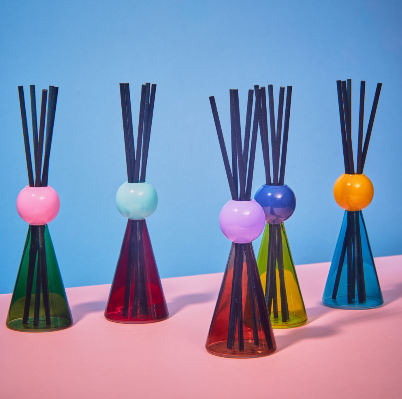 A collection of colorful WXY Disco 150ml diffusers with Reed Sticks, displayed against a two-tone background.
