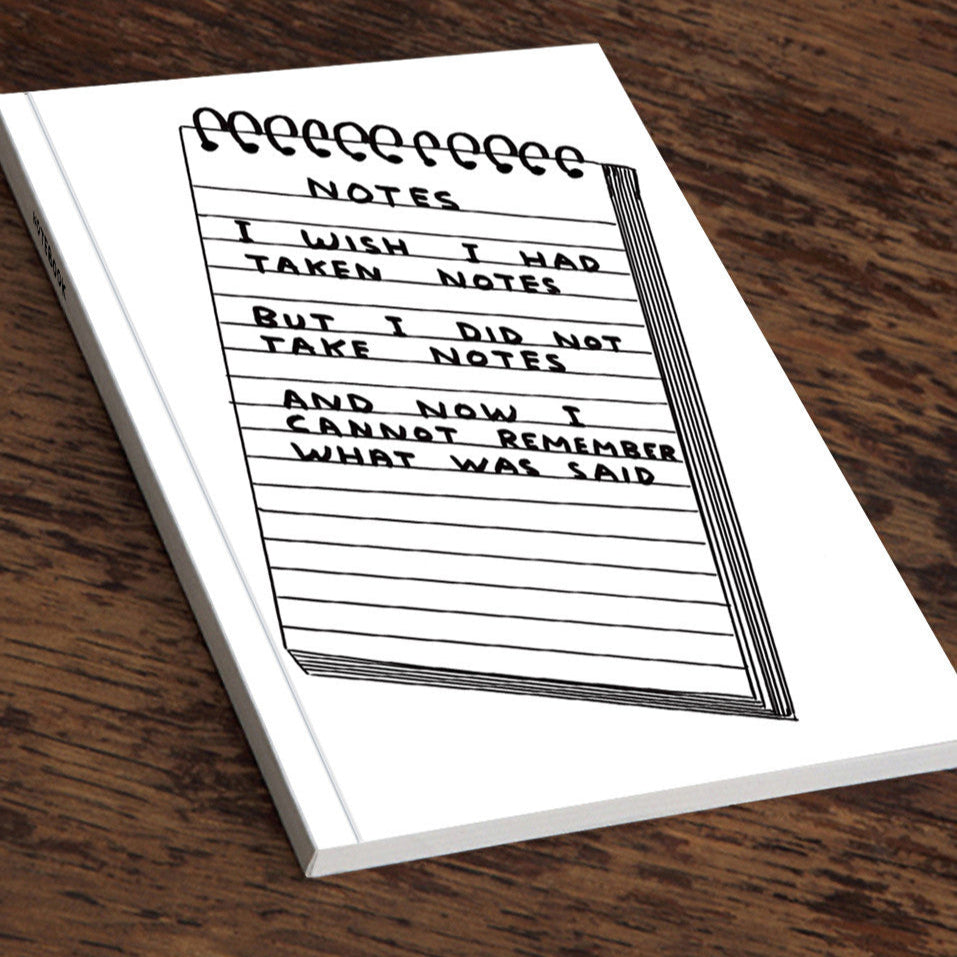 Notebook with humorous text and lined pages on a wooden surface.