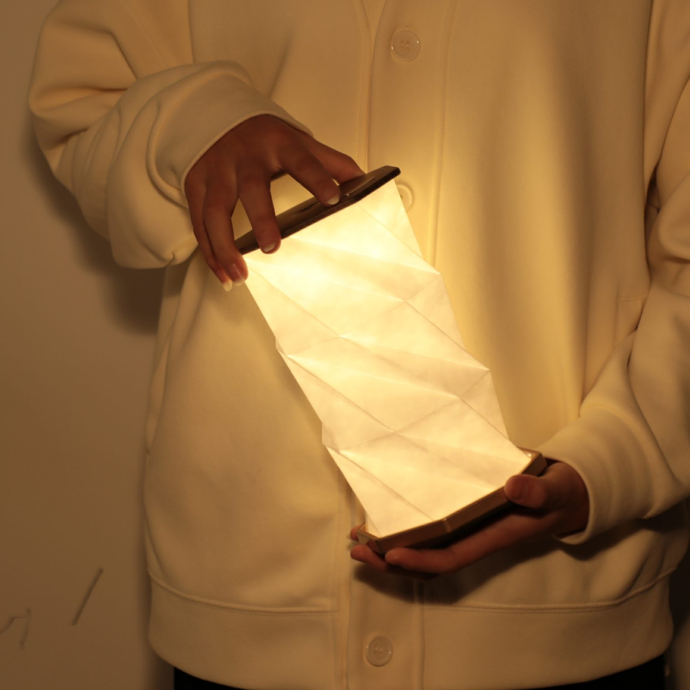A person holding the twist hexagon light emitting a warm glow.