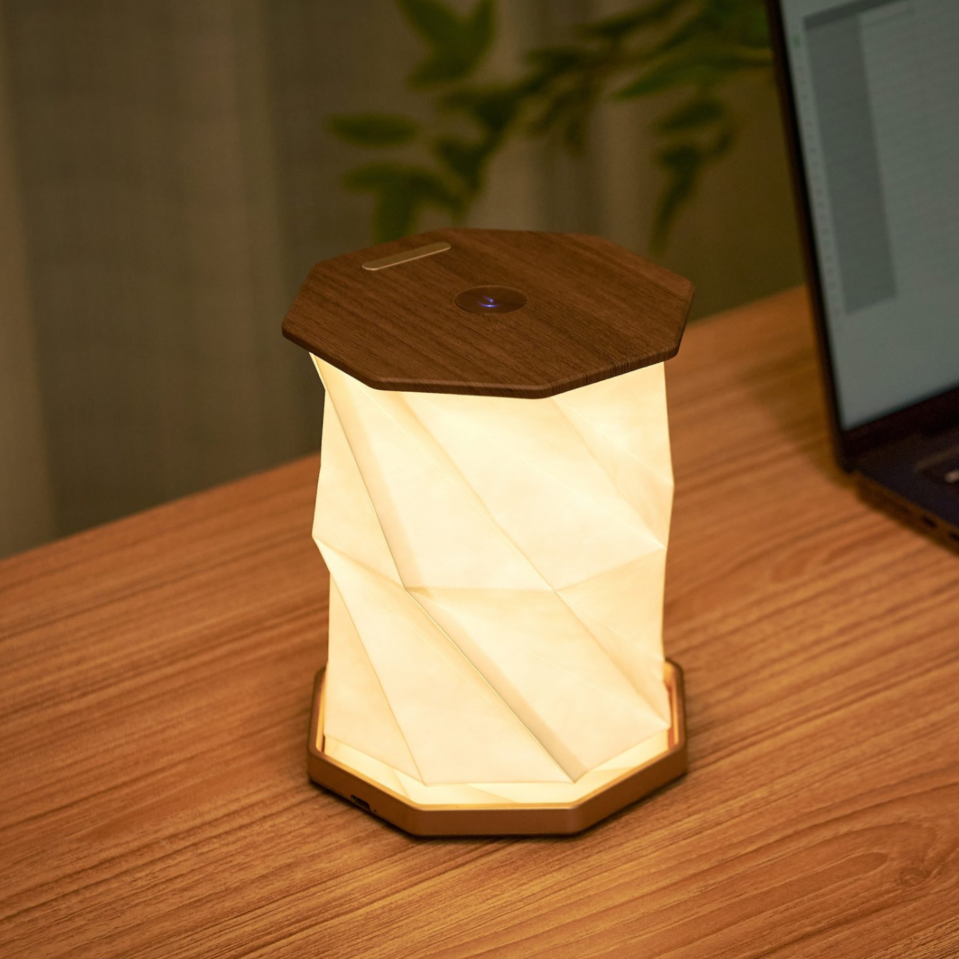 Modern Twist Hexagon Lamp with a warm white glow, placed on a wooden surface.