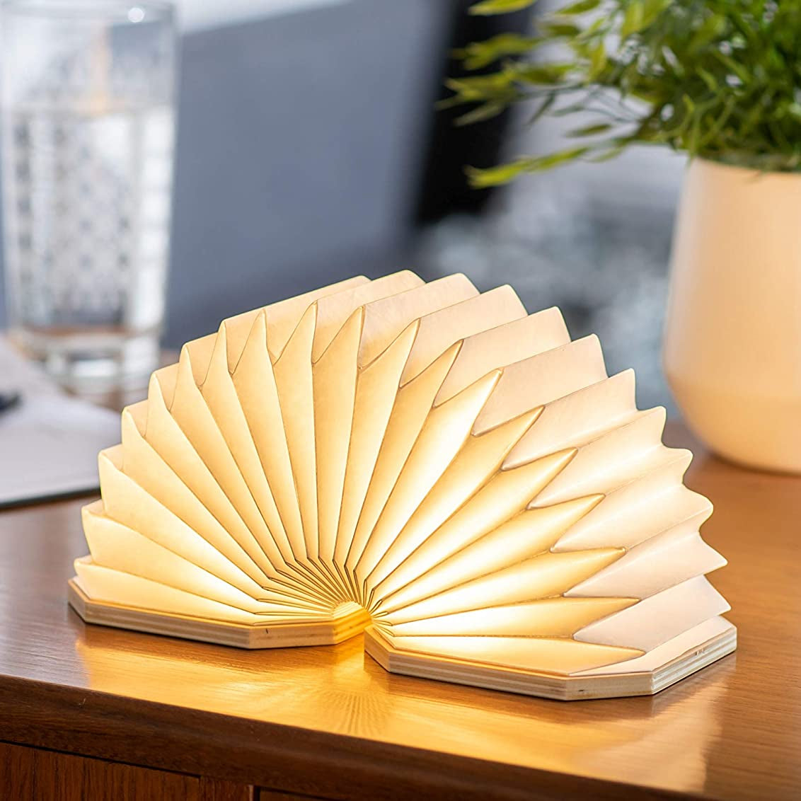 Foldable accordion-shaped lamp on a wooden surface