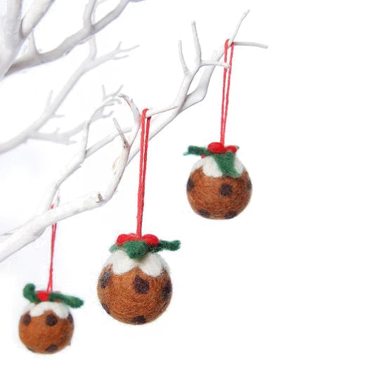 Three wool felt brown Christmas pudding decorations with holly and frosting, complete with a red hanging loop. All three and hung on a white tree branch.