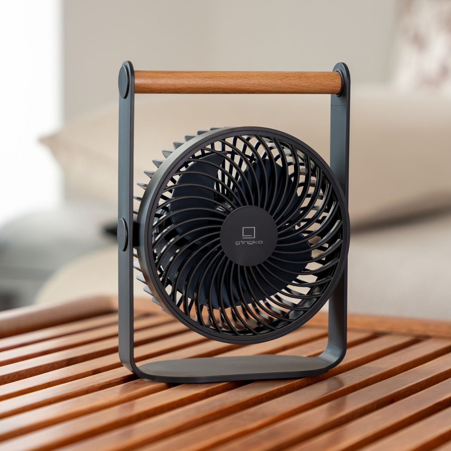 Portable fan on a wooden surface with a blurred background
