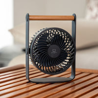 Portable fan on a wooden surface with a blurred background