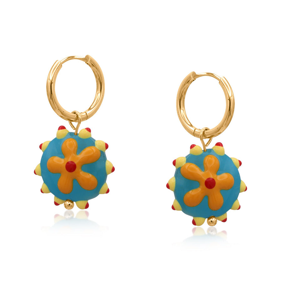 Pair of gold hoop earrings with blue floral charms on a white background
