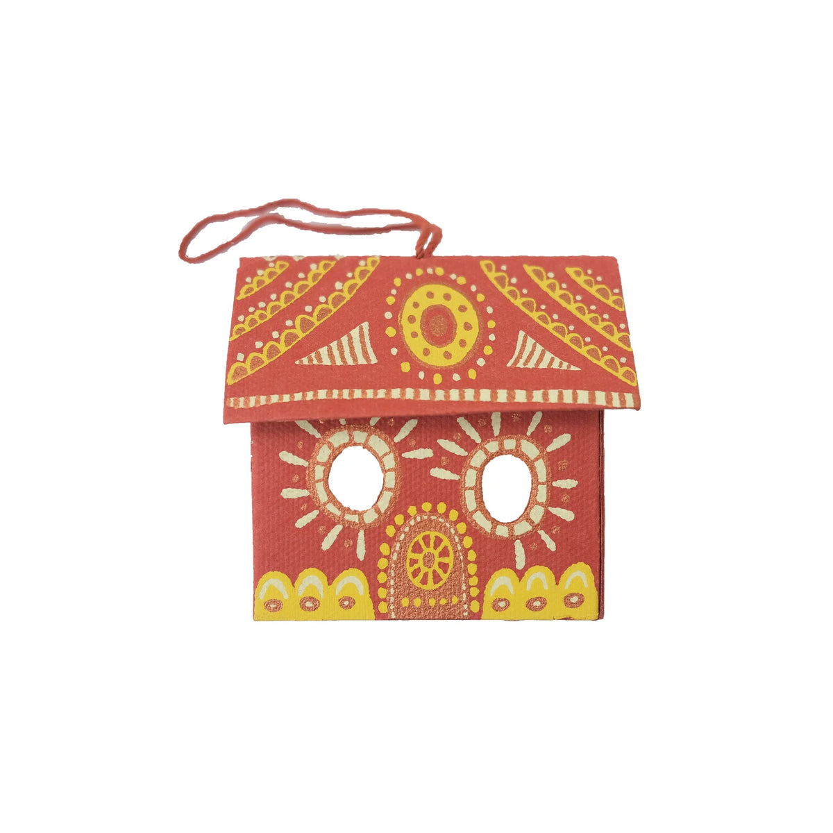 A small decorative house-shaped wall hanging or ornament with a red body, yellow and white painted patterns, and a red hanging loop on a white background.