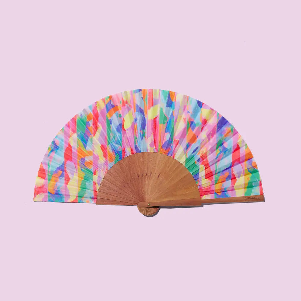 Colorful fan with a wooden handle on a pink background