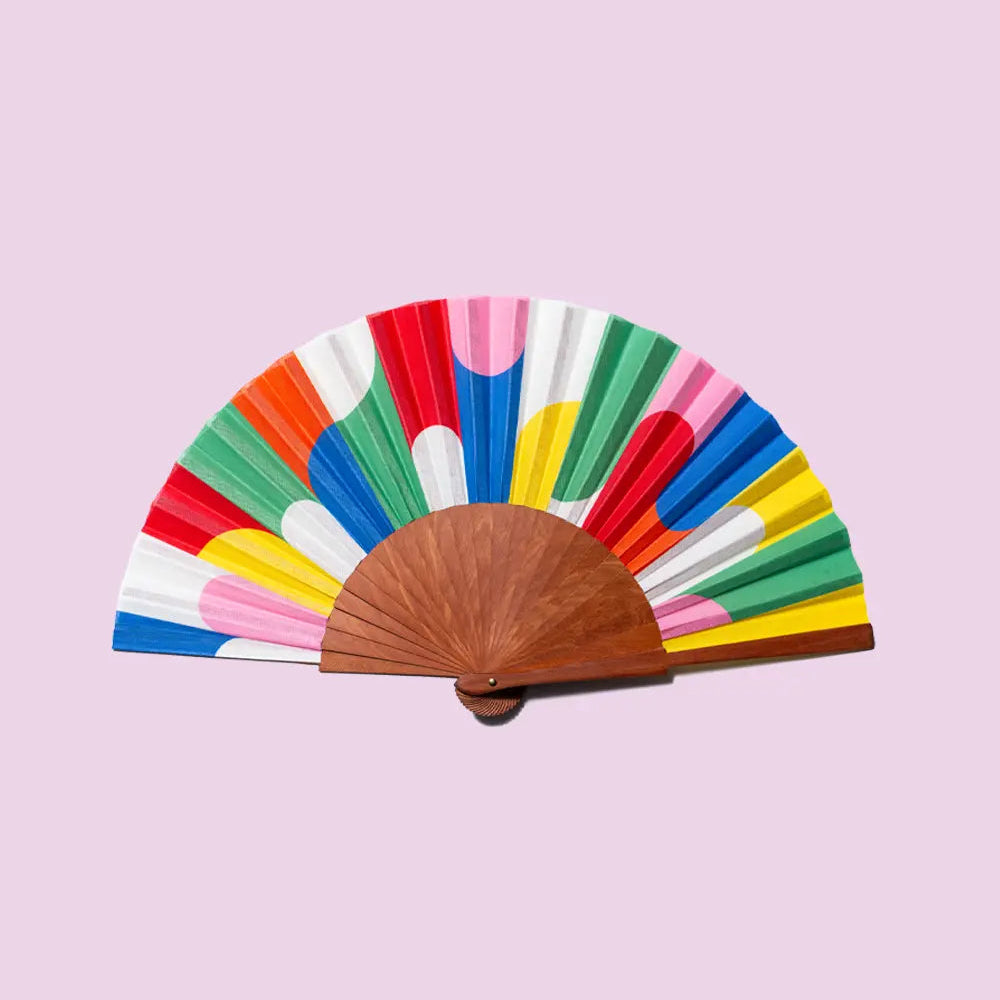 Colourful fan with wooden handle on a pink background