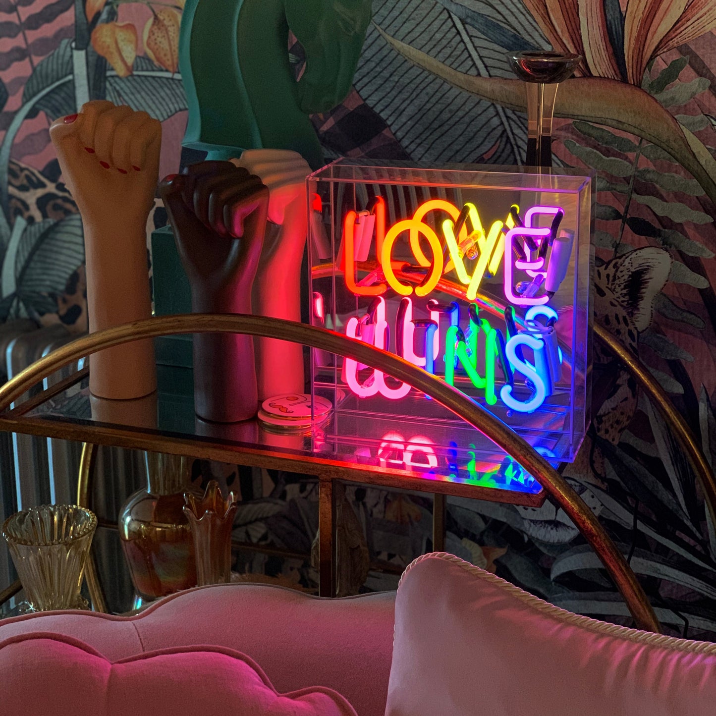 Neon sign with colourful letters on a bar counter with decorative elements.