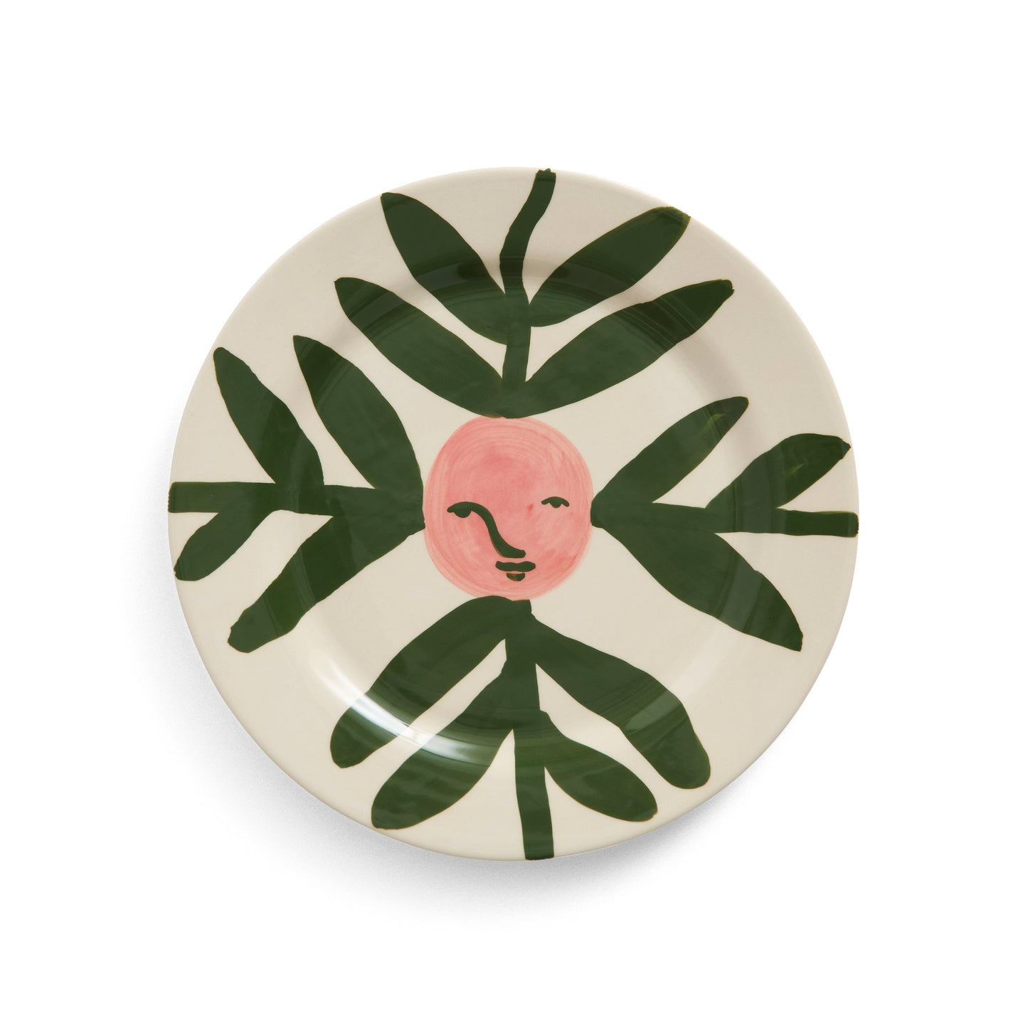 Stoneware plate with moon face and leaf design on white background