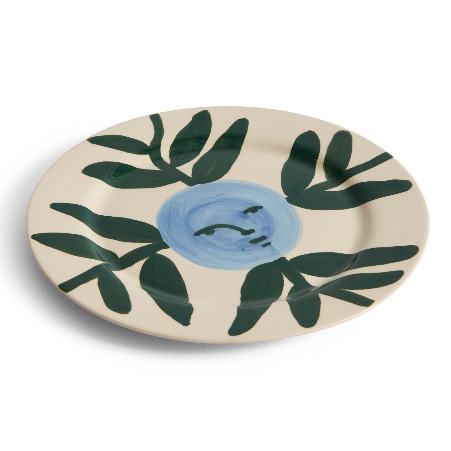 Ceramic plate with green leaf design and blue center on a white background
