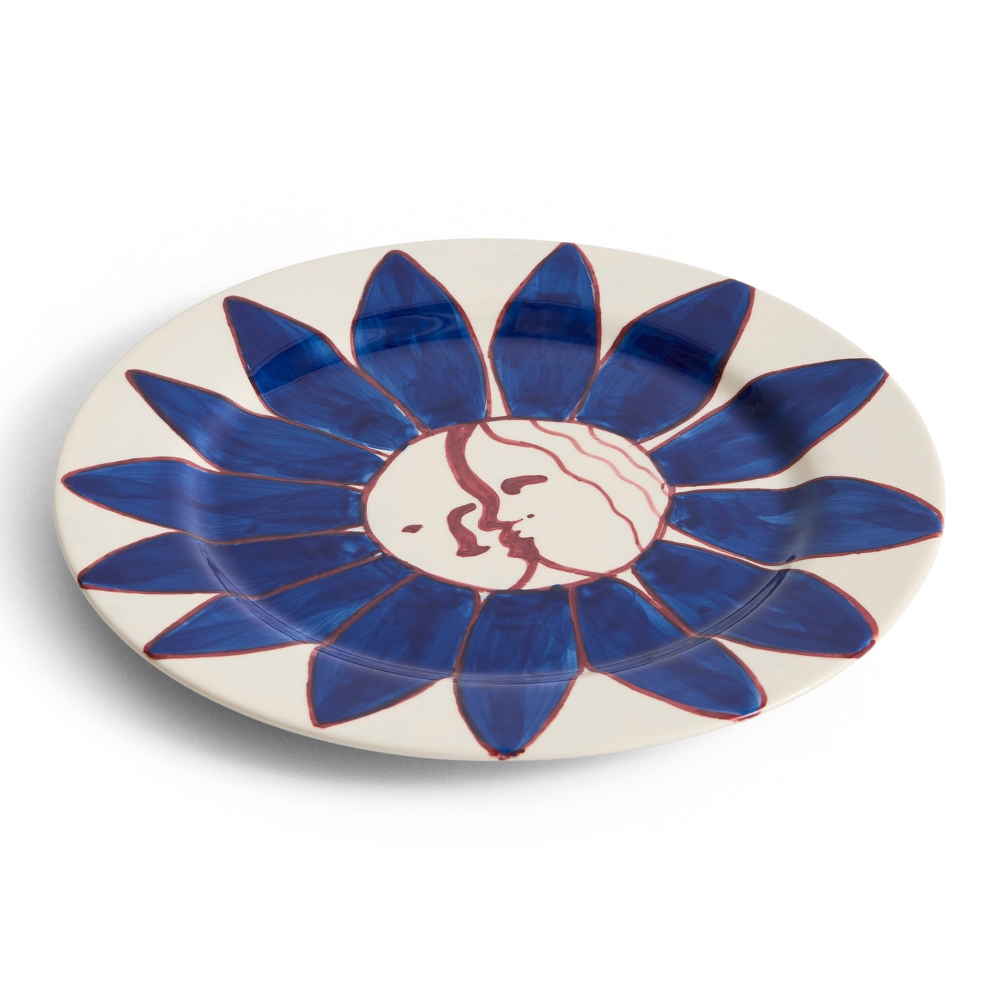 Decorative plate with blue floral design and face on a white background