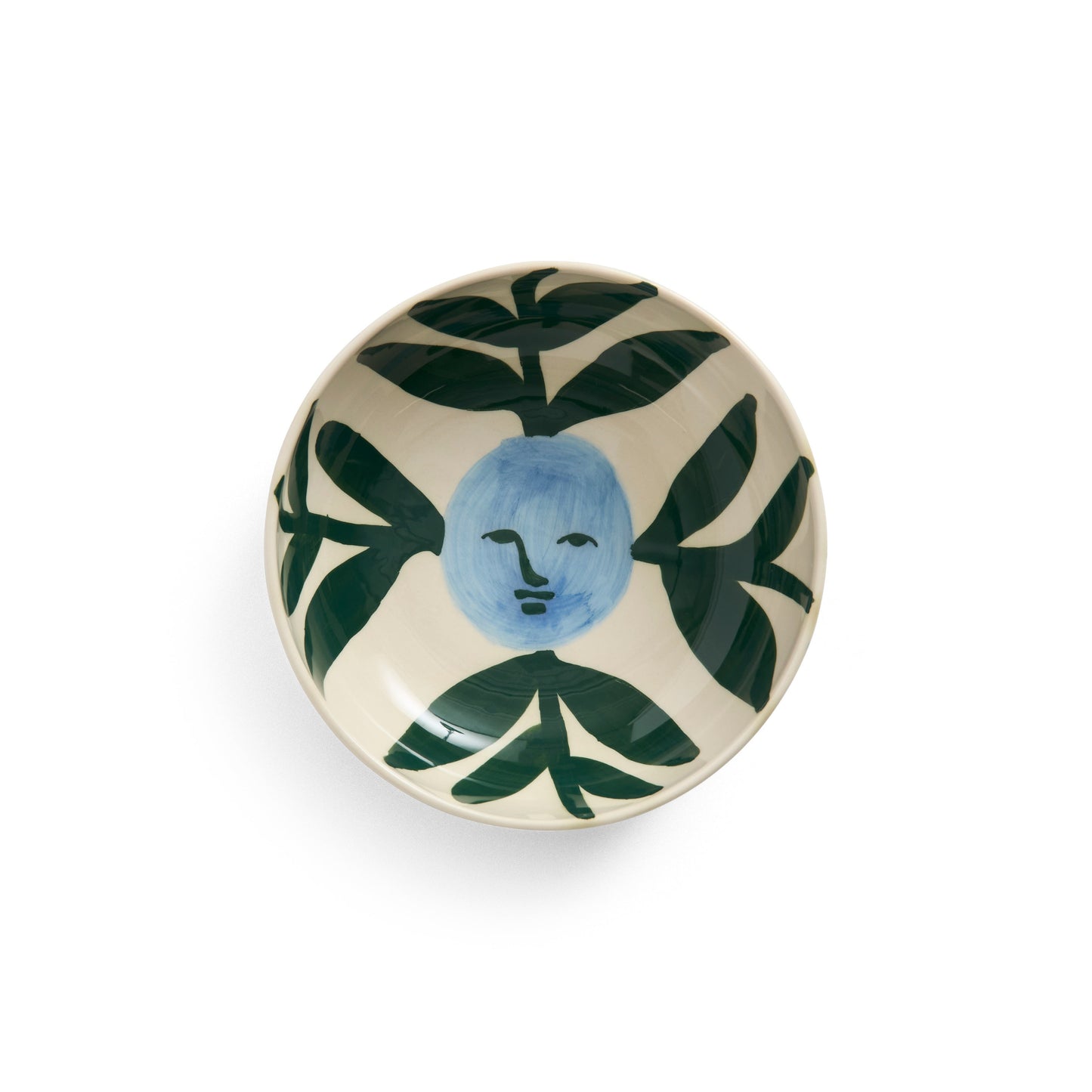 Ceramic dish with face and leaf design on a white background
