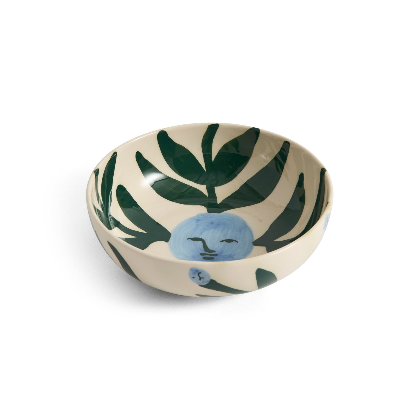 Small ceramic bowl with a moon face and leaf pattern on a white background