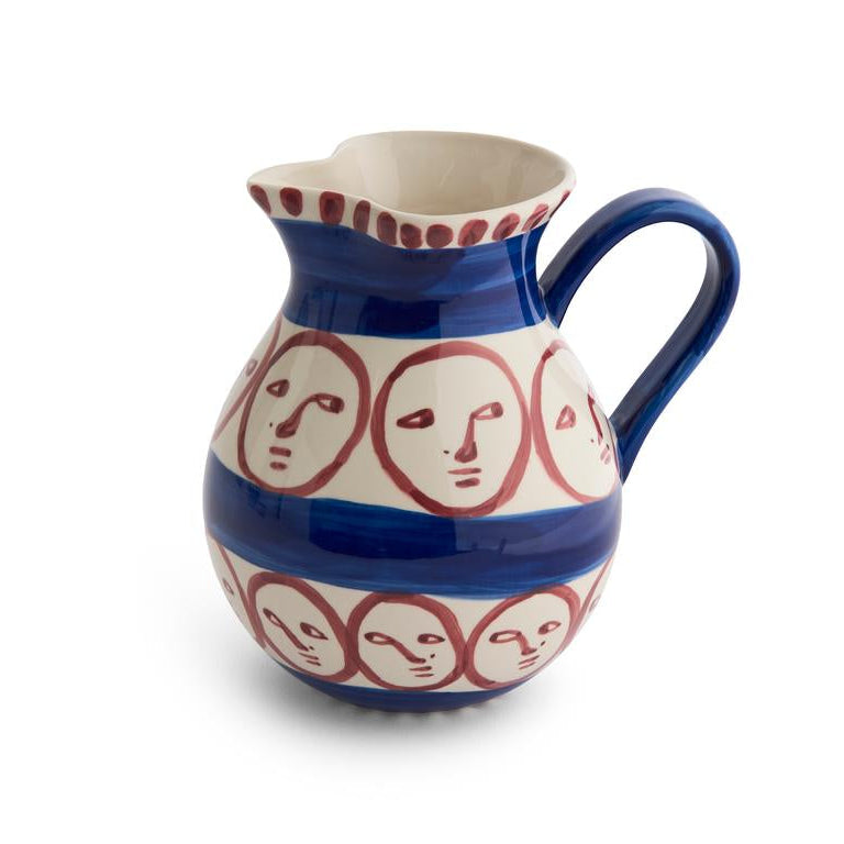 Ceramic pitcher with face patterns on a white background