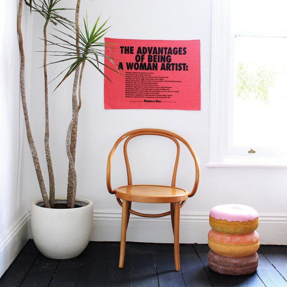 Advantages of Being a Woman Artist Teatowel hang up on a wall.