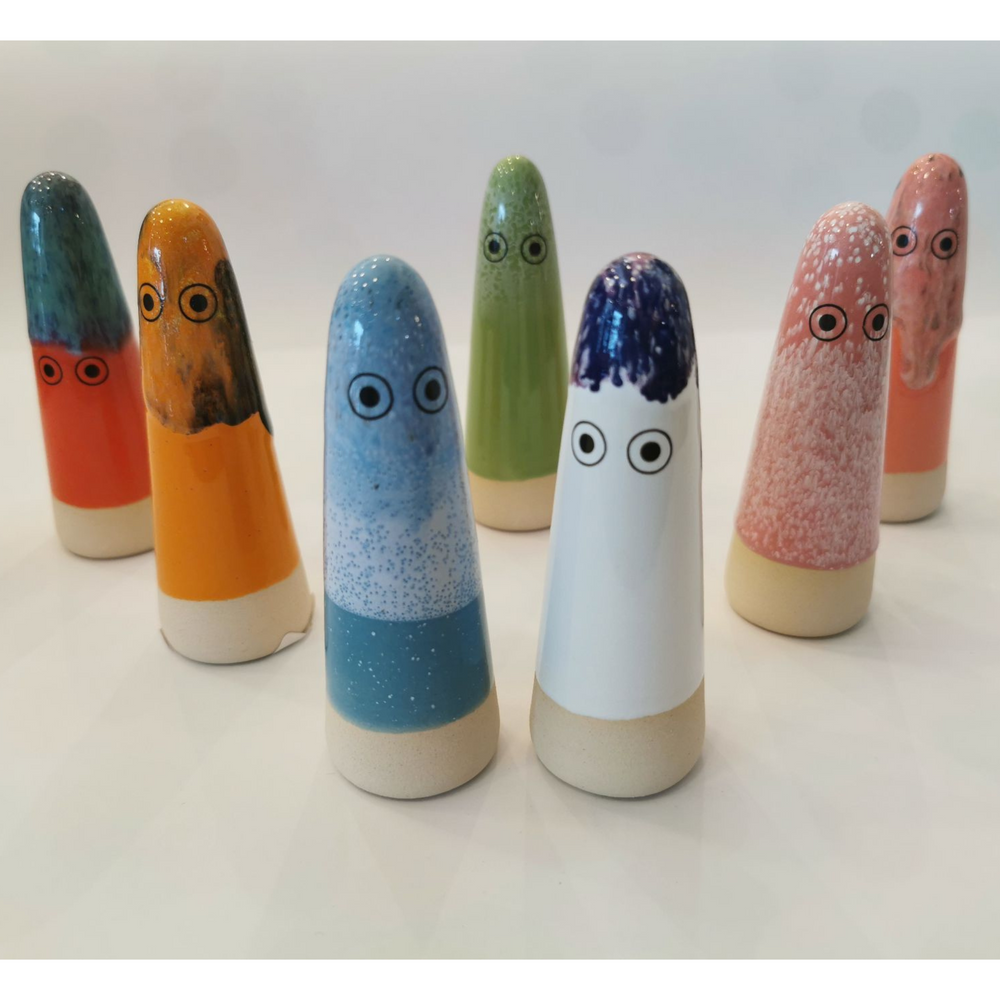 
                      
                        A group of 7 cone-shaped ceramic figurines with hand-painted eyes
                      
                    