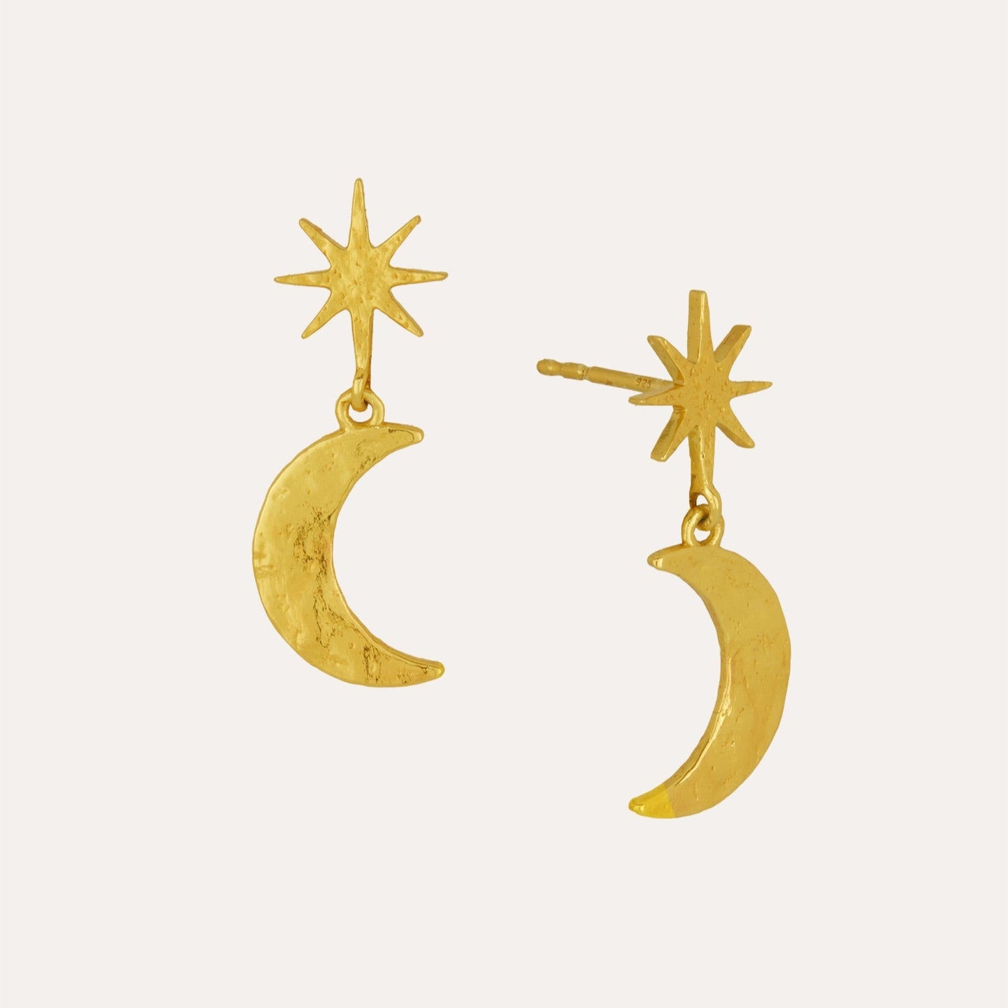 Gold earrings with star and crescent moon designs on a white background