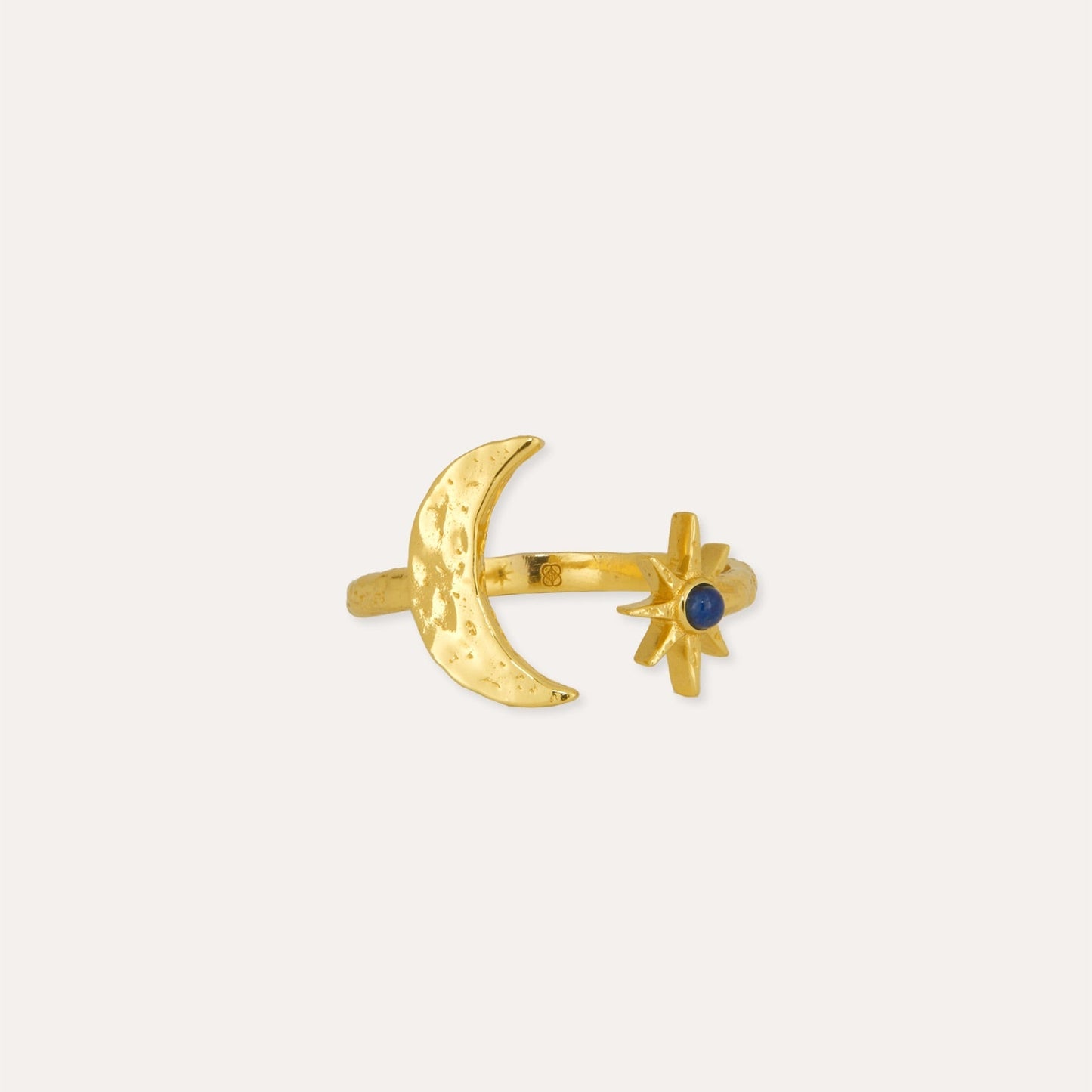 Gold ring with moon and star design on a white background