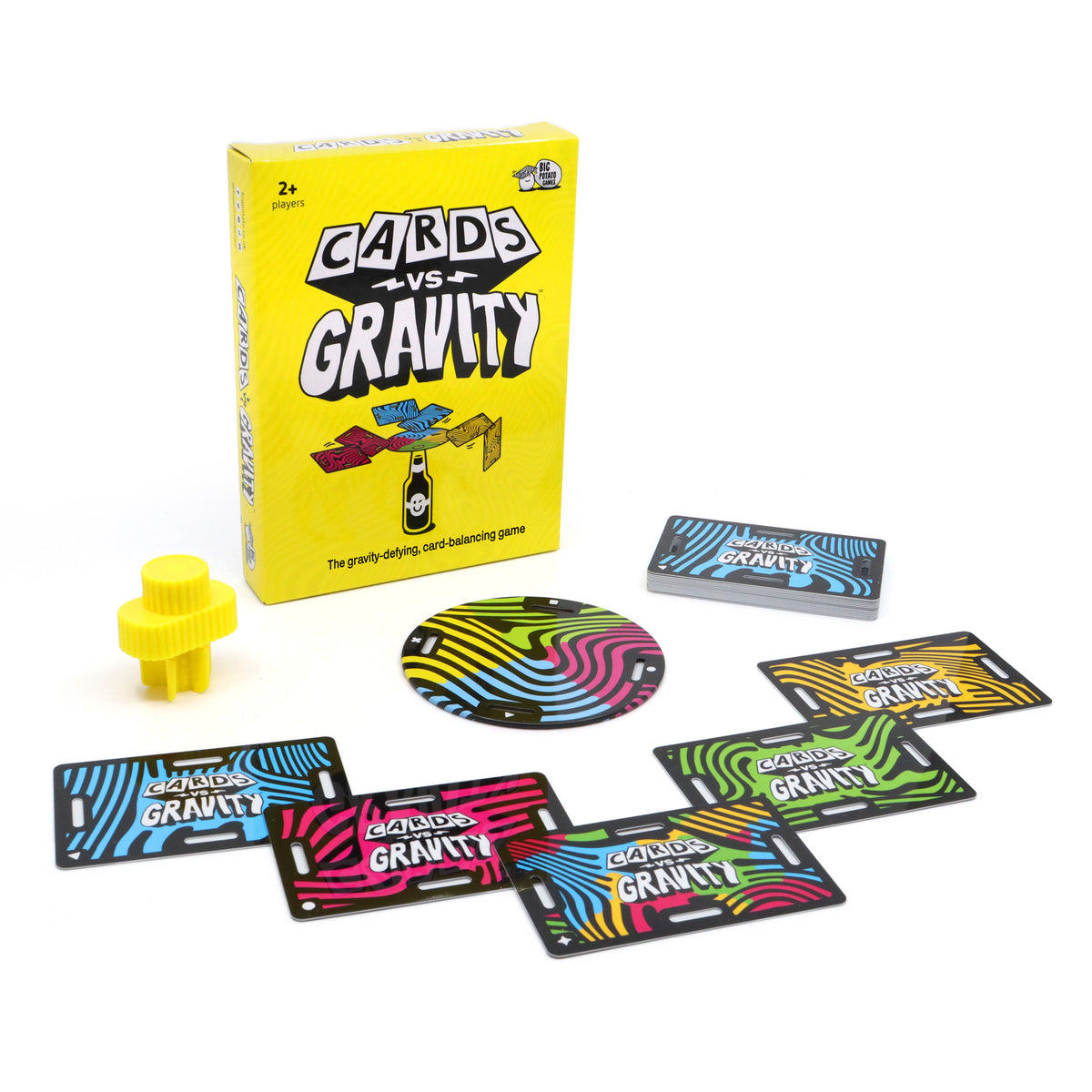 Cards vs Gravity game set with a bright yellow box, a yellow spinner, and several colourful cards arranged on a white background.