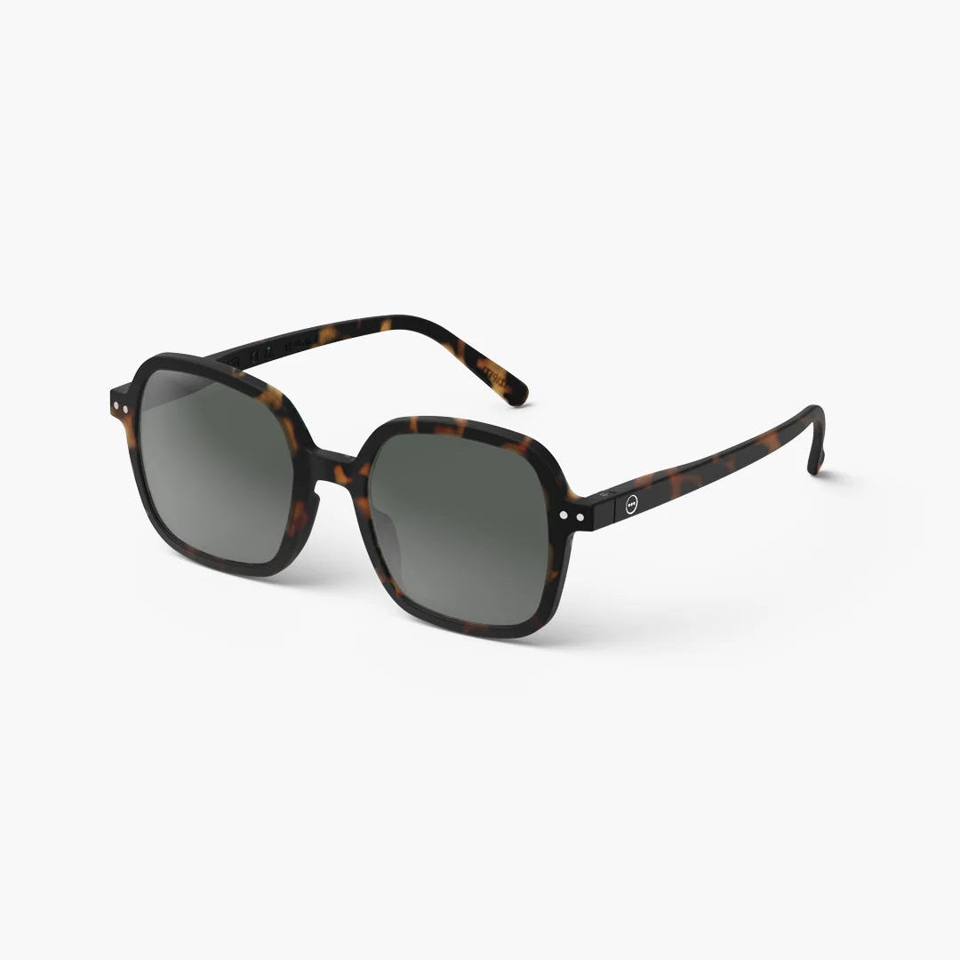 Sunglasses with tortoiseshell frame and dark lenses on a white background