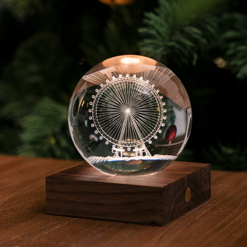 
                  
                    A crystal ball light on a wooden base featuring a ferris wheel design inside.
                  
                