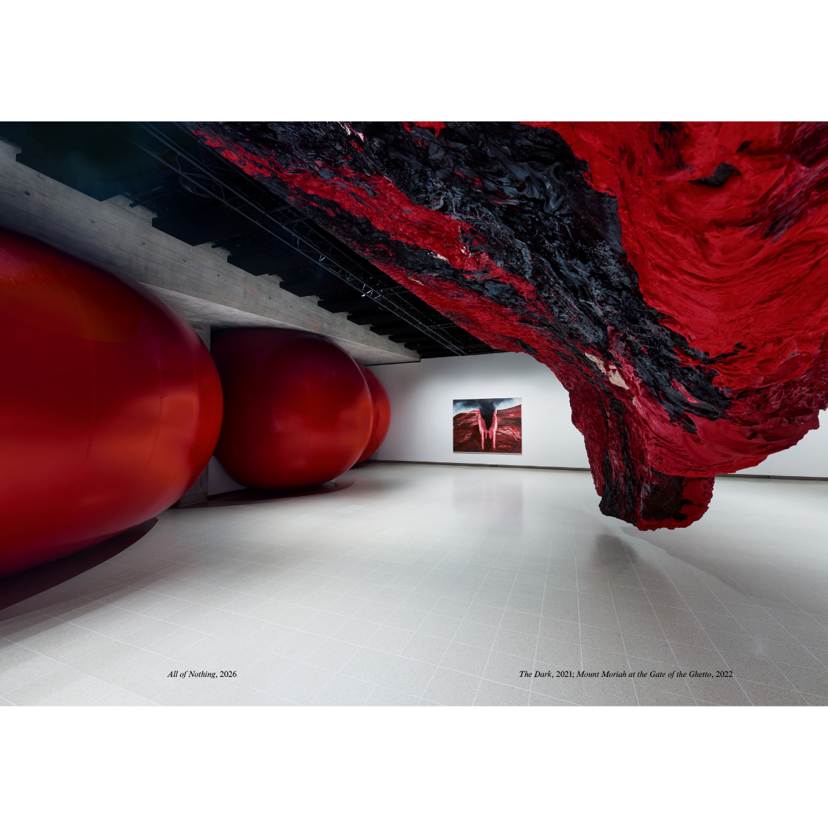 Art installation with large red and black sculptures in a gallery setting.