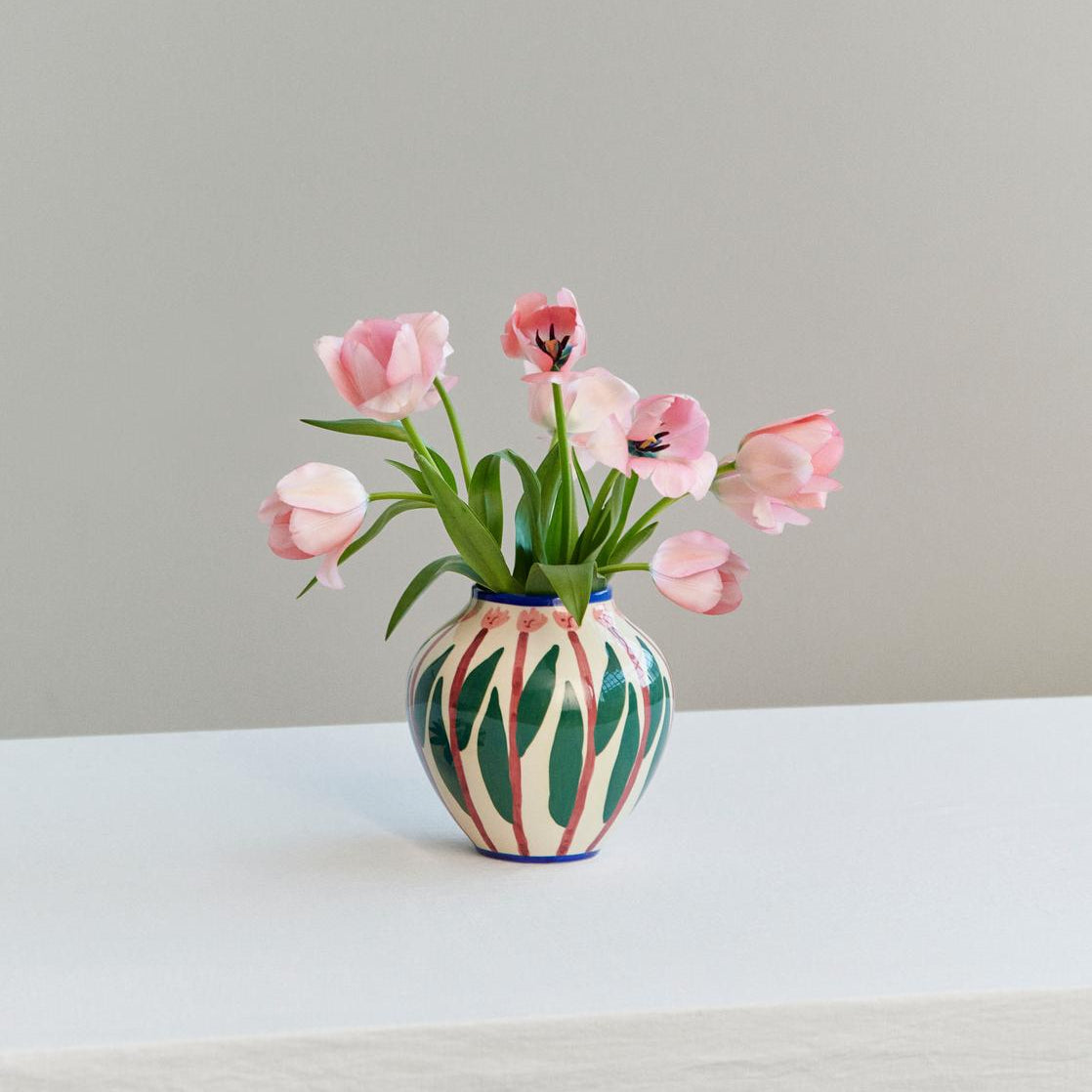 Decorative vase with pink tulips on a neutral background