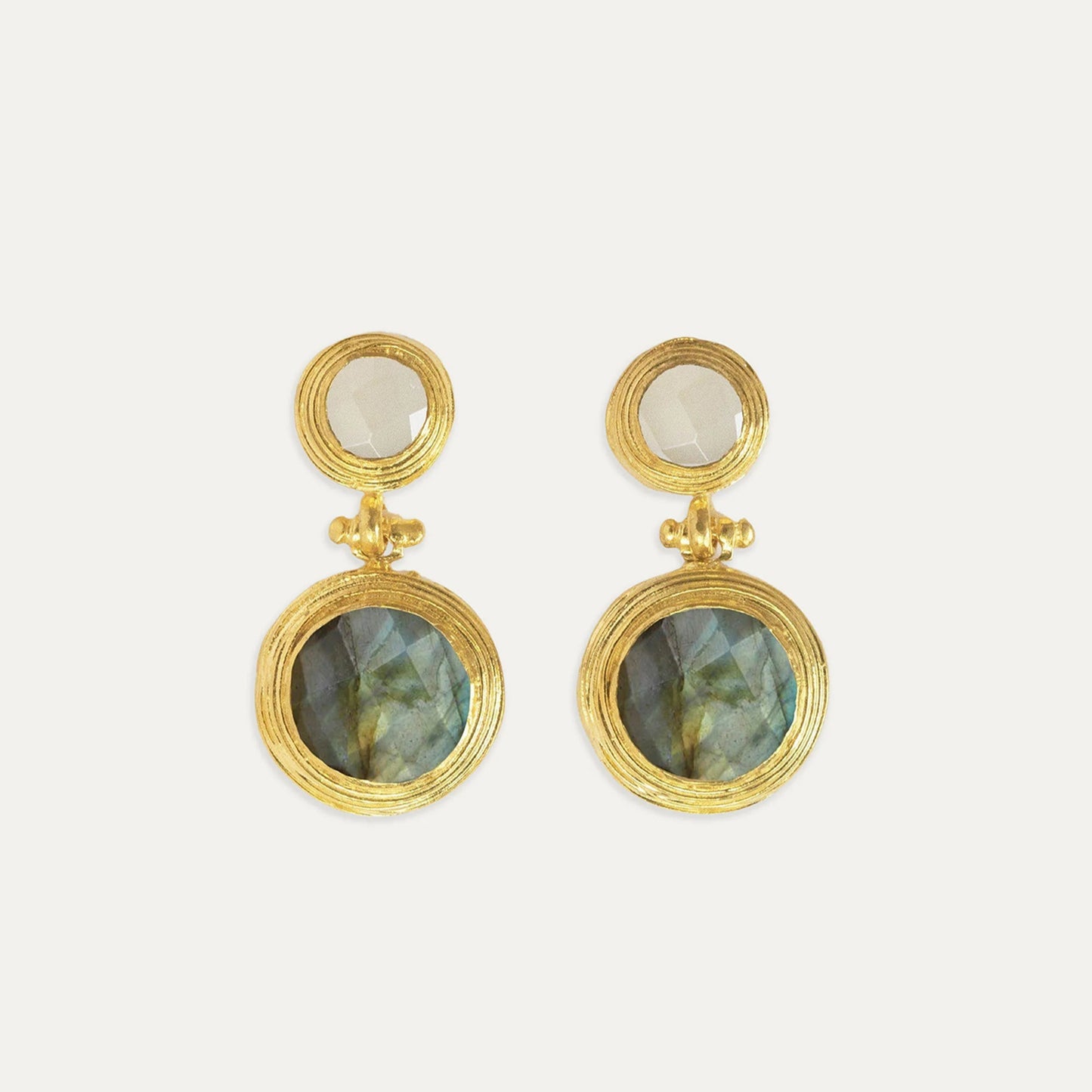 Gold earrings with circular stone designs on a white background