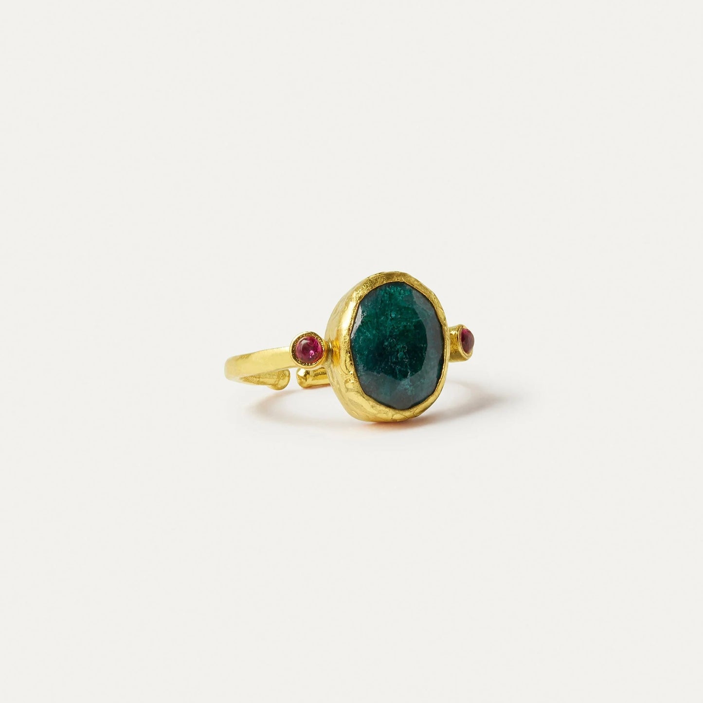 Gold ring with a green gemstone and red accents on a white background
