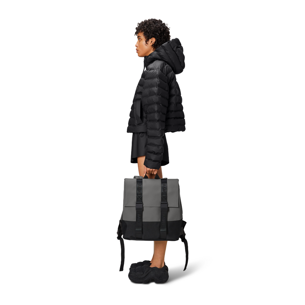 
                  
                    A person holding the Rains MSN Backpack Mini by the handle.
                  
                