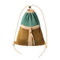 Two-tone pleated bag with green top and brown bottom on a white background