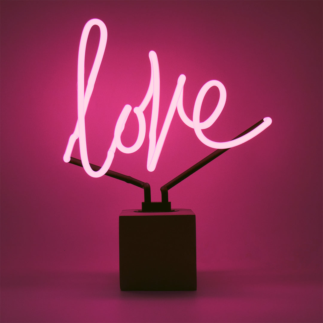 Neon sign with the word 'love' on a pink background