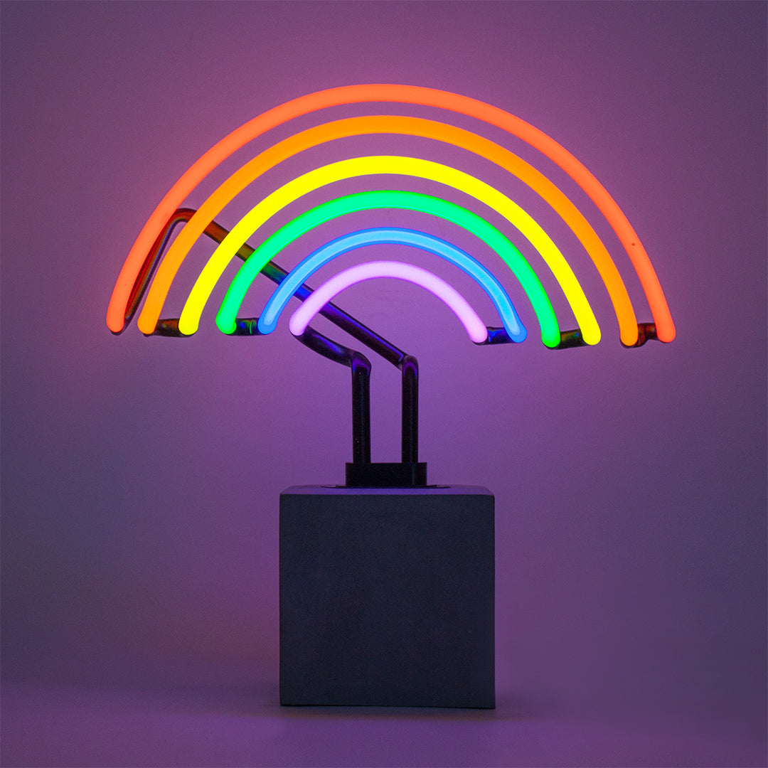 Neon rainbow shaped light with concrete base on a purple background