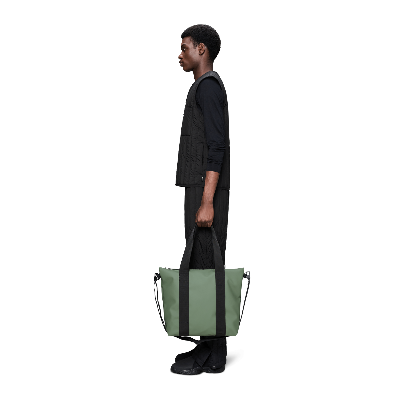 Person holding a green bag on a white background