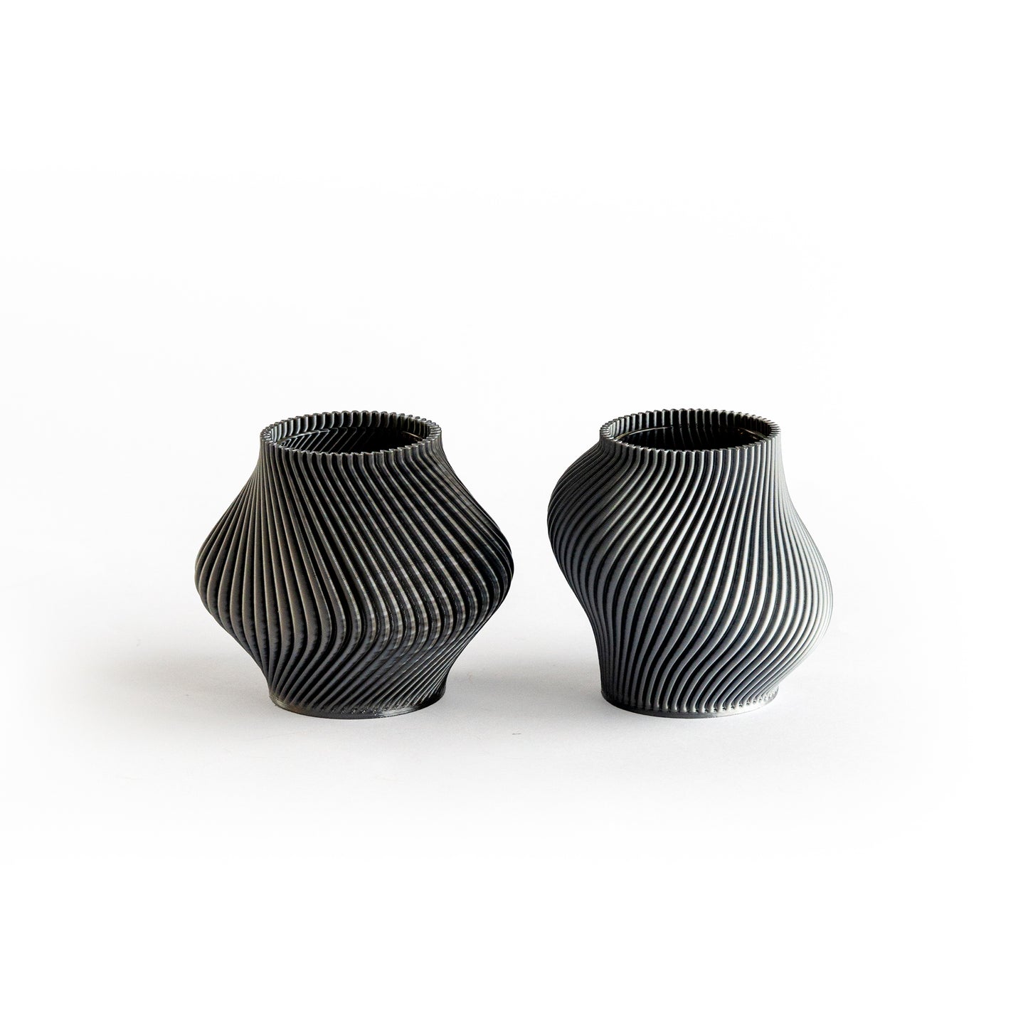 Two black textured vases on a white background