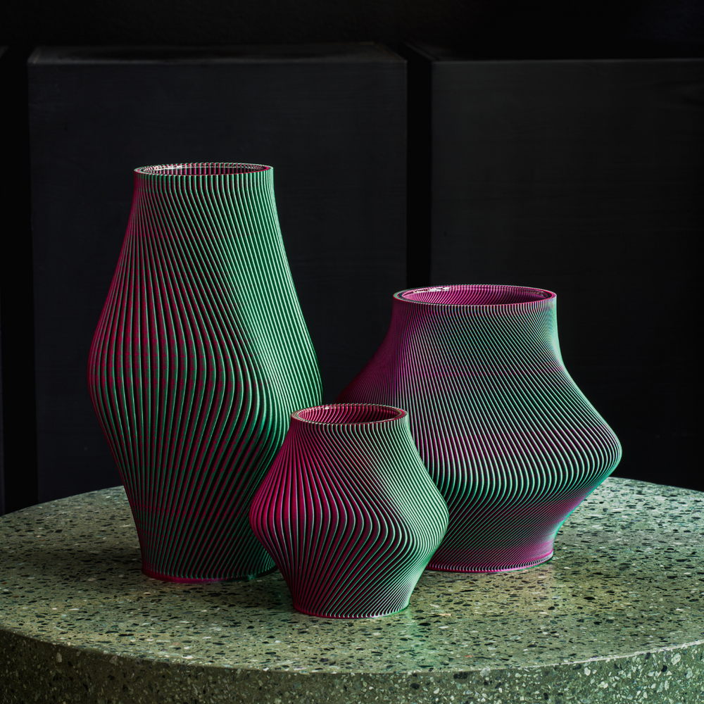 
                      
                        A lifestyle group shot of three 3D printed vases of different sizes on a stone round table.
                      
                    