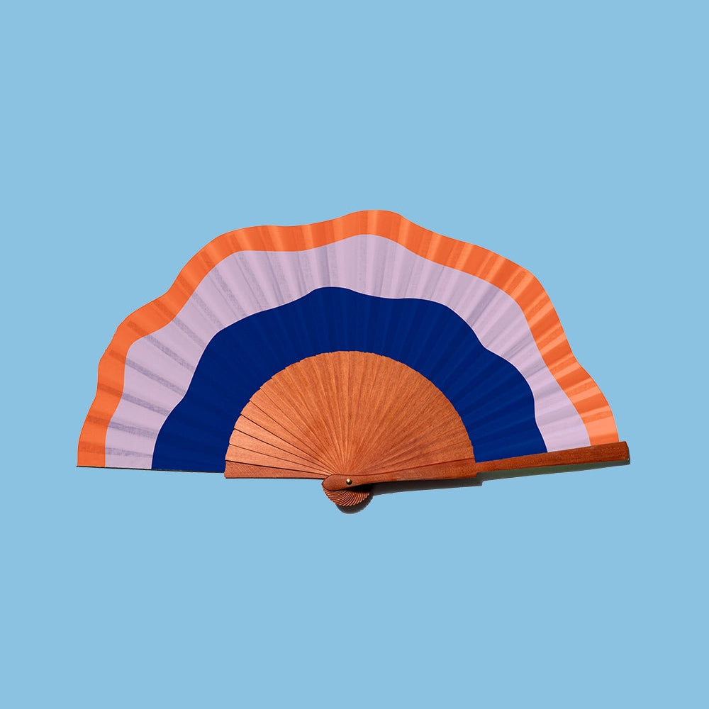 Colourful hand fan with orange, blue, and pink stripes on a light blue background