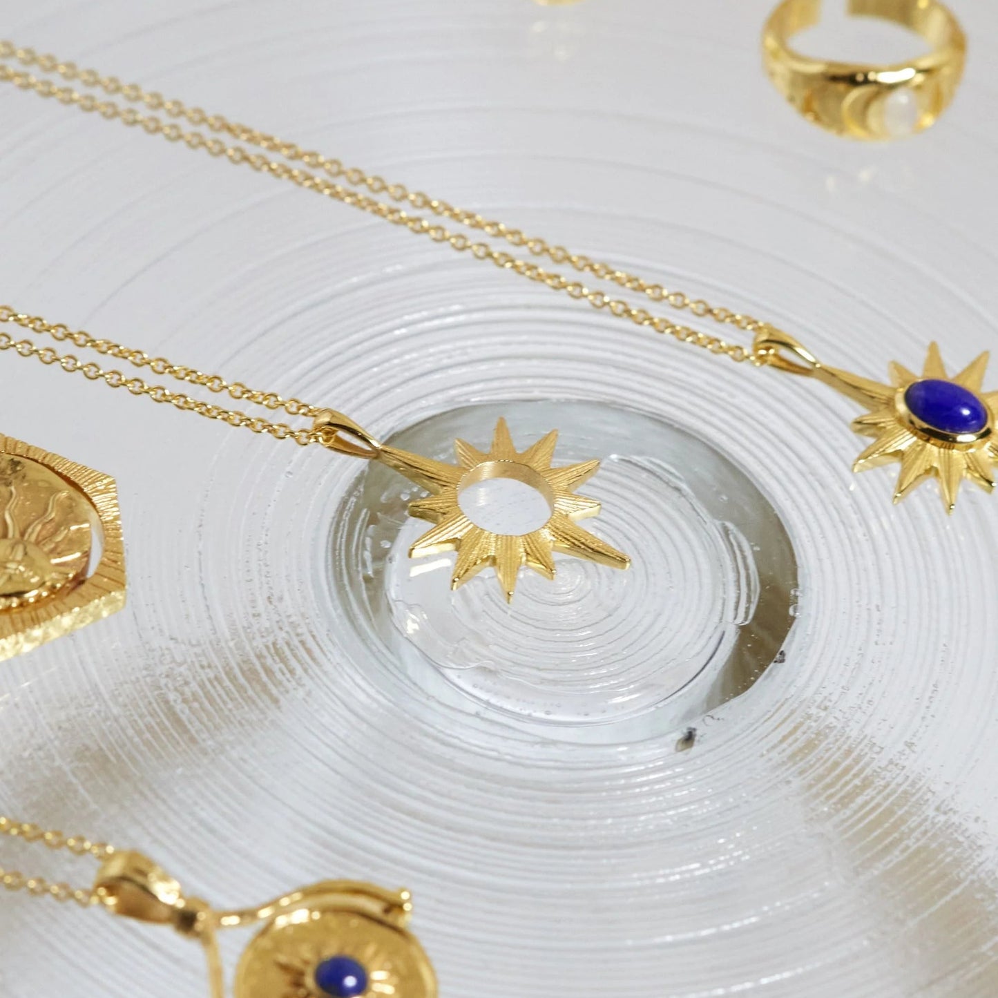 Gold jewelry with star-shaped pendants on a white surface