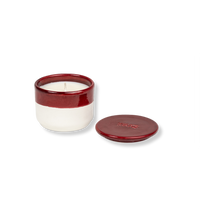 Ceramic candle with red and white design on a white background