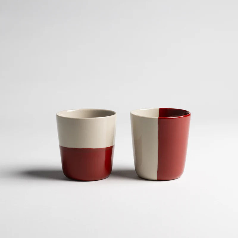 Two ceramic cups with a two-tone design on a white background