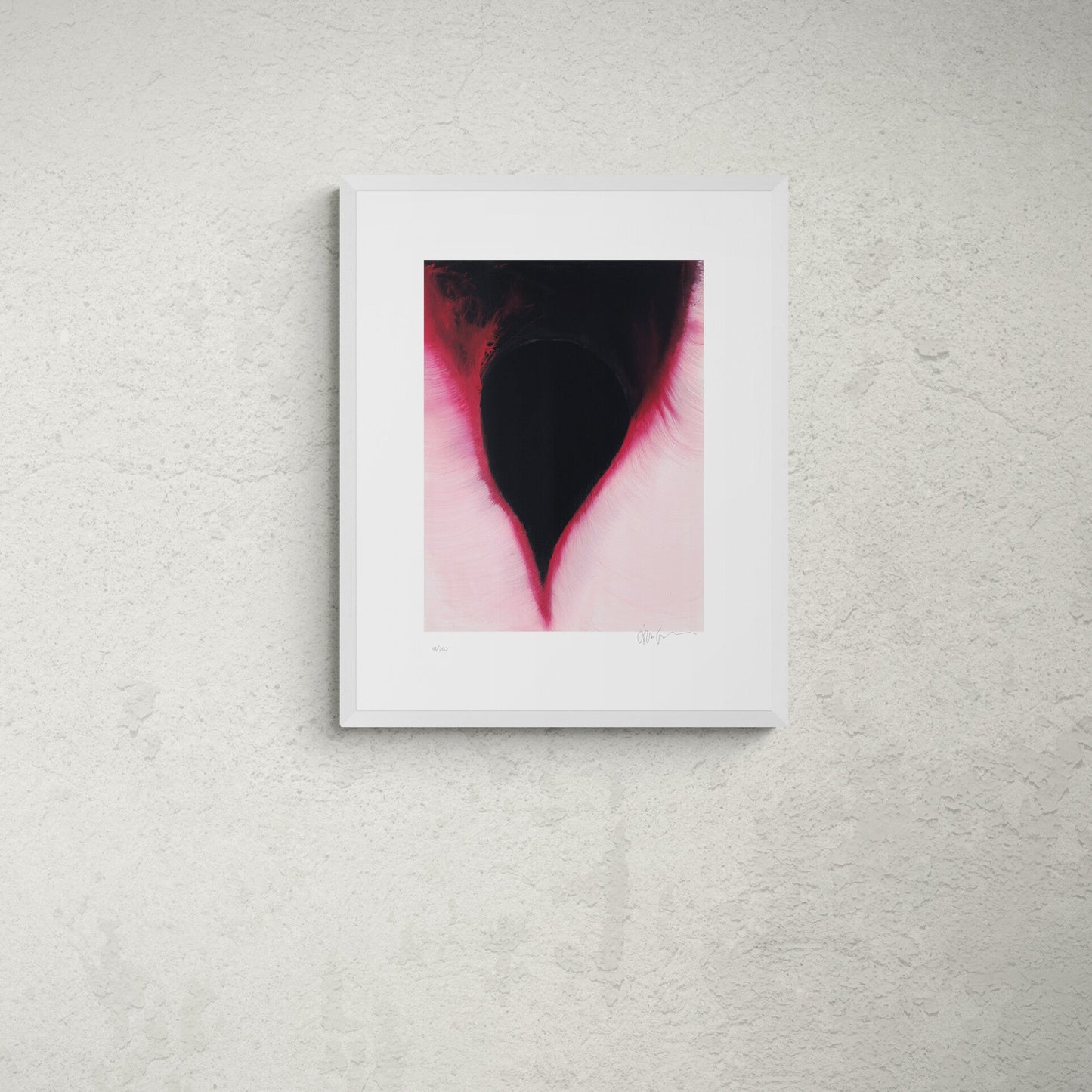 Framed abstract art piece on a wall above a wooden table with art supplies.
