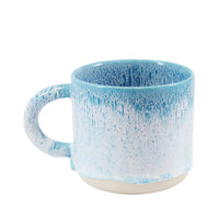A ceramic mug with a large handle, featuring a blue and white speckled design.