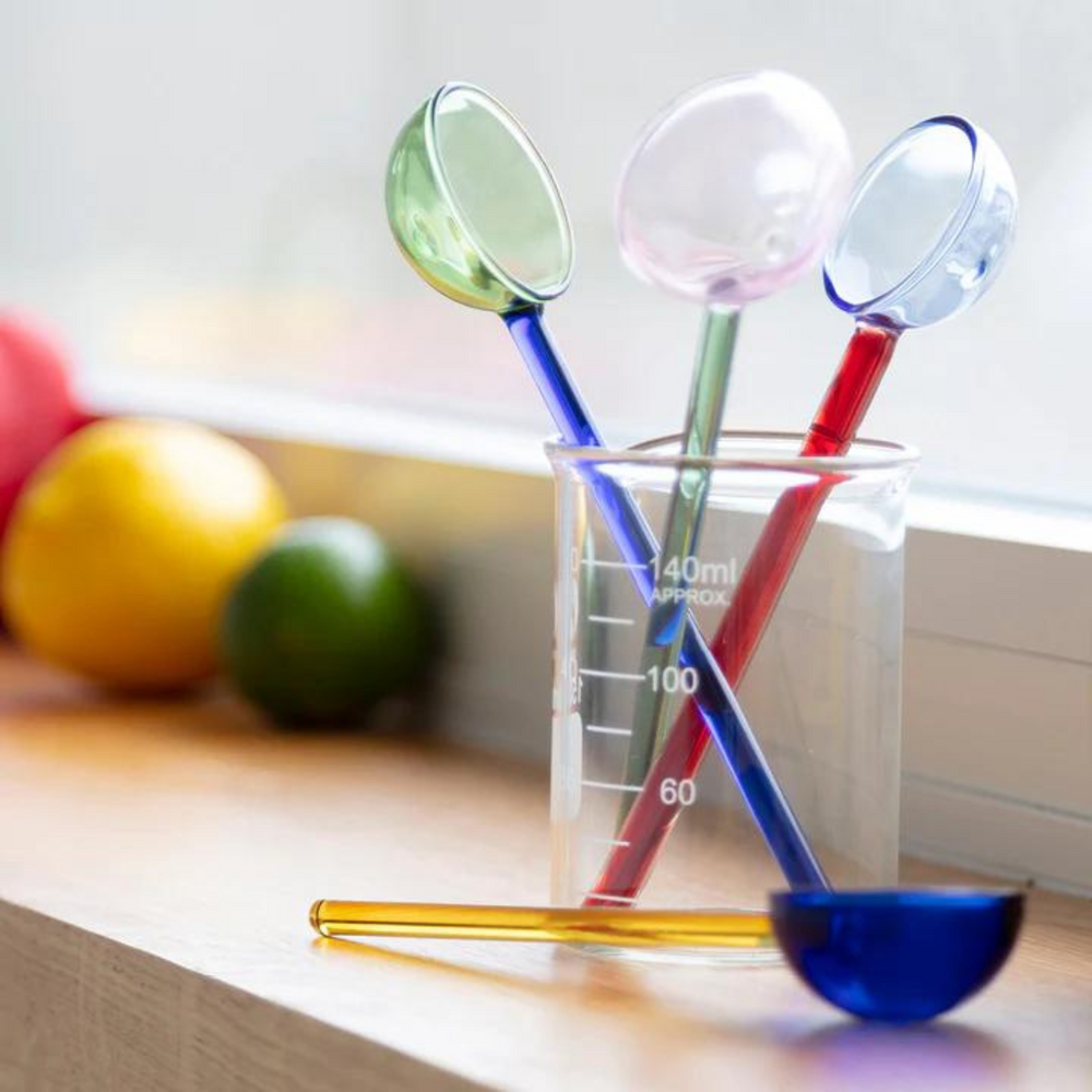 
                      
                        glass beaker holding assorted colour glass spoons.
                      
                    